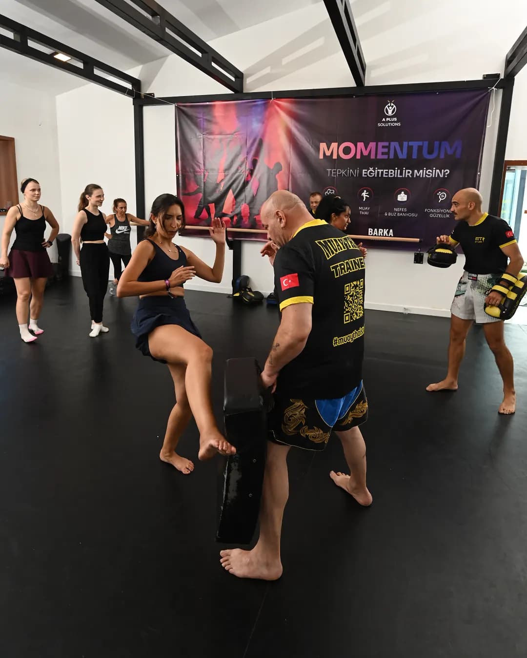 Pad tutan eğitmene tekme atan muay thai katılımcısı