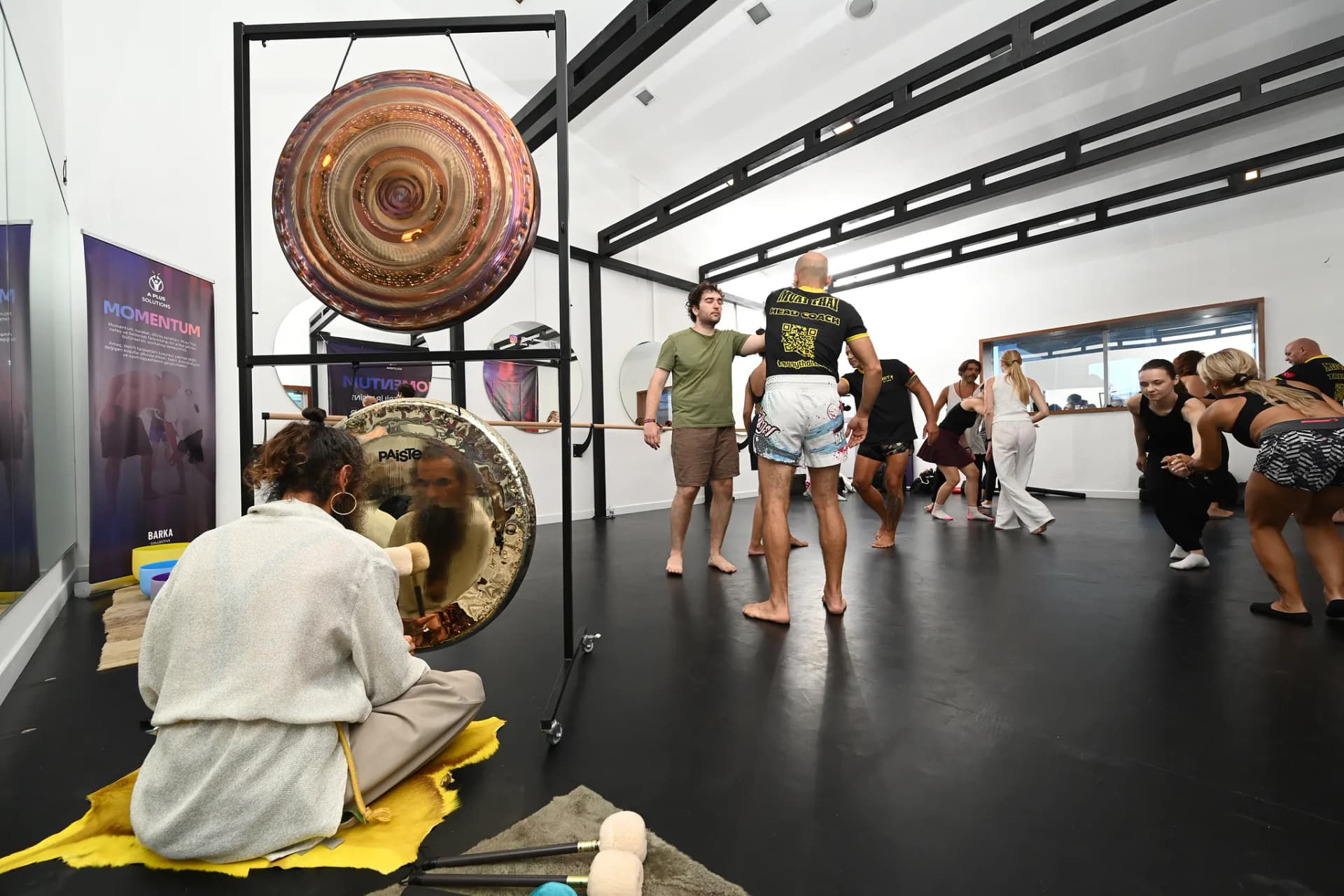 Önde gong çalan eğitmen, arkada muay thai ve hareket grupları