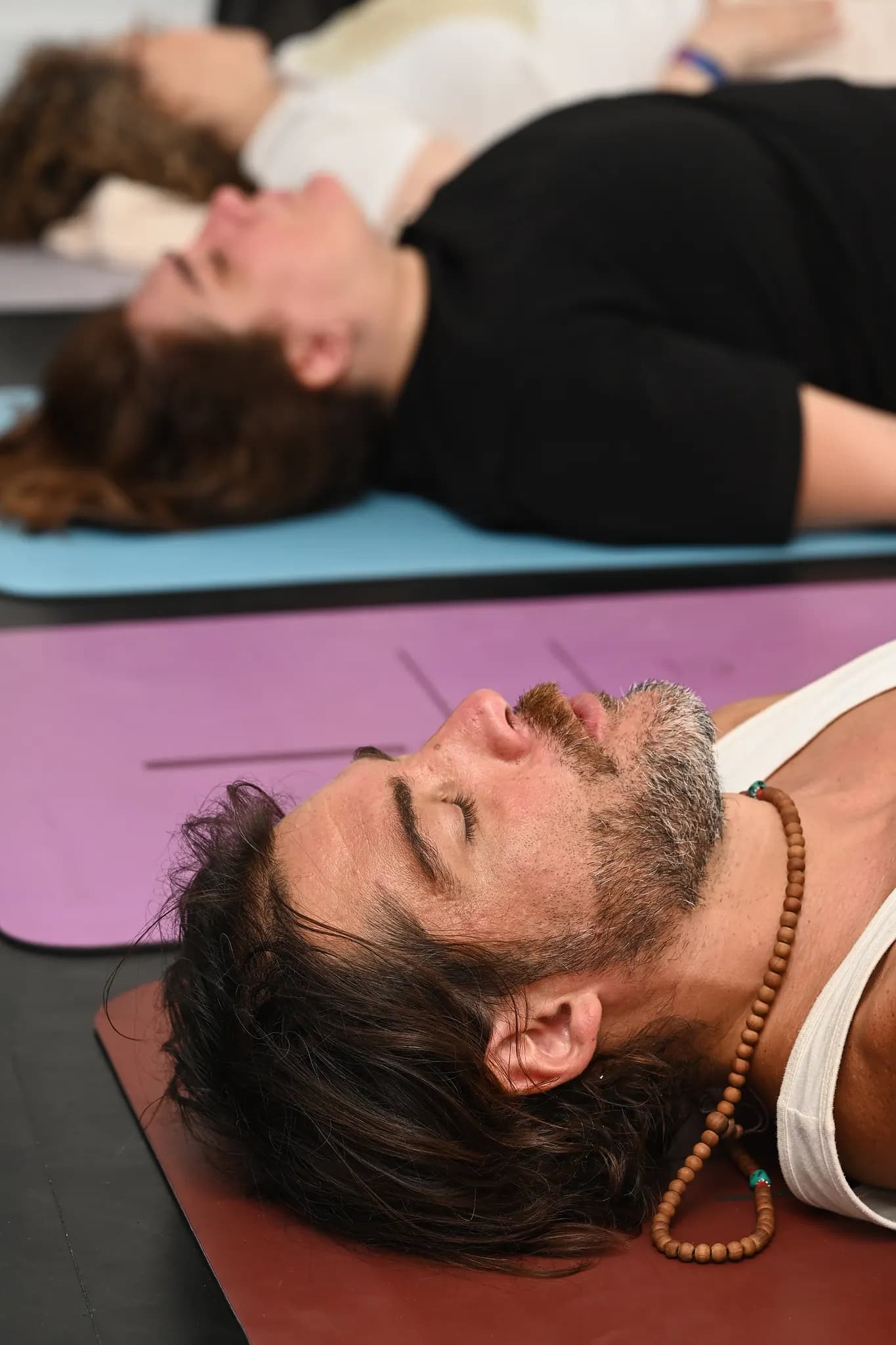 Ses meditasyonu sırasında matlara uzanmış katılımcılar